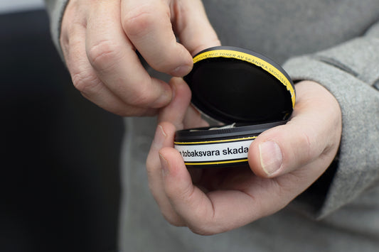 Guy Opening a Can of Nicotine Pouches